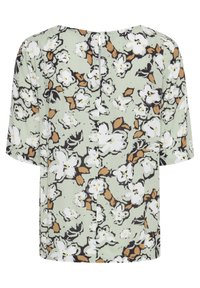 Blouse vert clair à manches courtes, présentant un motif floral blanc et brun et une couture centrale au dos.
