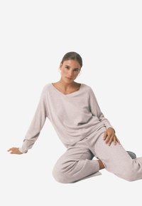 Lys grå loungewear sæt med en løstsiddende langærmet top med V-udskæring og matchende tapered bukser med ribbet tekstur.