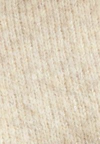 Crèmekleurige gebreide stof met een gestructureerde uitstraling, inclusief een subtiele glans en een consistent patroon van in elkaar grijpende steken.
