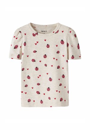 Kremowa koszulka dla malucha z krótkimi, bufkowatymi rękawami, ozdobiona wzorem czerwonych biedronek i małych czerwonych serc.