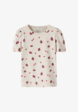 Kremowa koszulka dla malucha z krótkimi, bufkowatymi rękawami, ozdobiona wzorem czerwonych biedronek i małych czerwonych serc.
