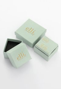 Hellgrüne Geschenkboxen aus Papier mit goldener Beschriftung, im quadratischen Format und mit einer strukturierten Oberfläche; eine Box ist geöffnet und zeigt ein schwarzes Innenleben.