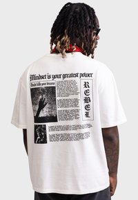 Weißes Baumwoll-T-Shirt mit grafischem Druck, schwarzem Text, Bildern und handgezeichneten Illustrationen auf der Rückseite. Lockerer Schnitt, kurze Ärmel.