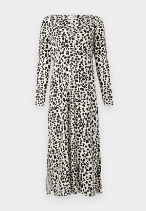 Pikk, kreemjas kleit mustade täppide mustriga, millel on pikad varrukad, V-kaelus ja külgslõige mugavuse saavutamiseks.