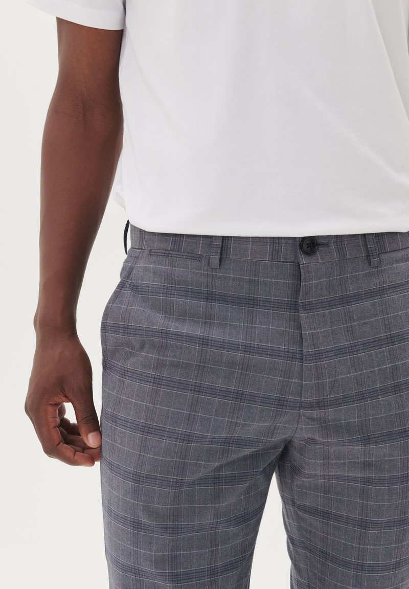 Grijze geruite broek met een knoopsluiting en riemlussen, vervaardigd uit een gestructureerde stof, met een subtiel ruitpatroon en zijzakken.