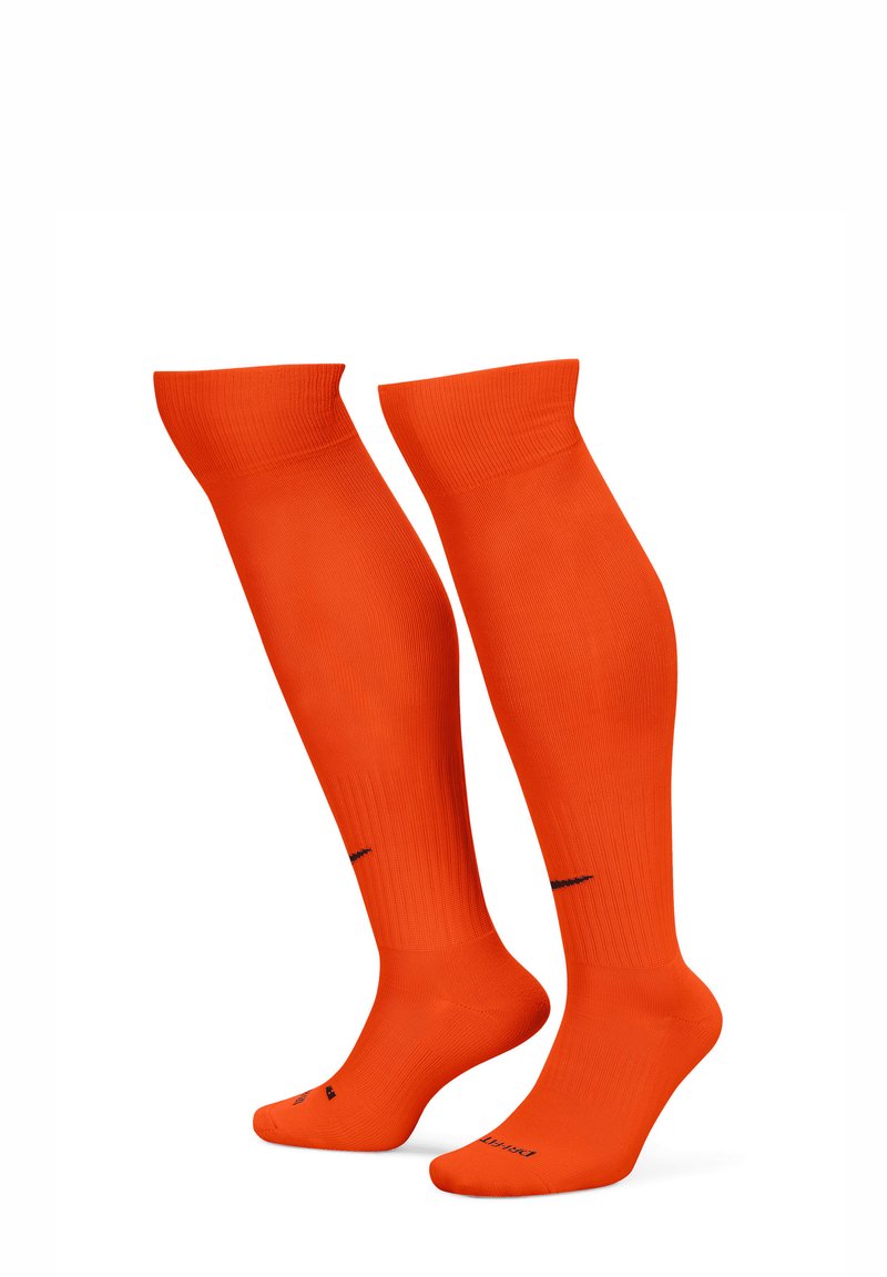 Calze fino al ginocchio di colore arancione luminoso, con texture a coste e una finitura liscia. Il logo nero sulla suola aggiunge contrasto.