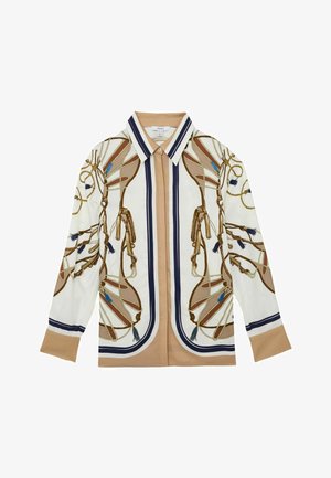 Langärmlige Bluse zum Knöpfen mit beigem Grundton, weißen und marineblauen Streifen sowie aufwendigen goldfarbenen Kordel- und Quastenmustern auf Vorderseite und Ärmeln.