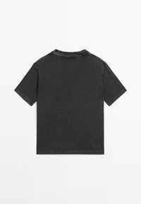 T-shirt nera a maniche corte, realizzata in tessuto simile al denim, con scollatura a girocollo e dettagli di cucitura visibili lungo i bordi.