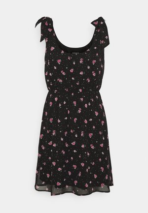 Robe noire sans manches avec imprimé floral rose, bretelles à nouer, taille cintrée et jupe légèrement évasée.
