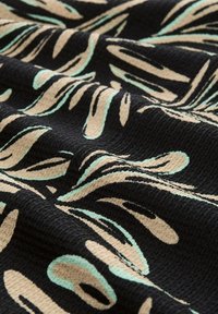 Tessuto nero con una superficie testurizzata, caratterizzato da un motivo astratto in beige e verde menta. Il design include forme fluide e curve.