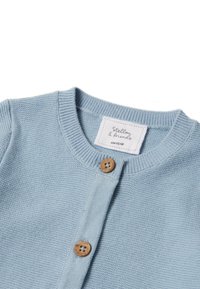 Cárdigan de punto azul claro con cuello redondo, botones de madera y una etiqueta que dice "Stello & Friends", talla 62/68.