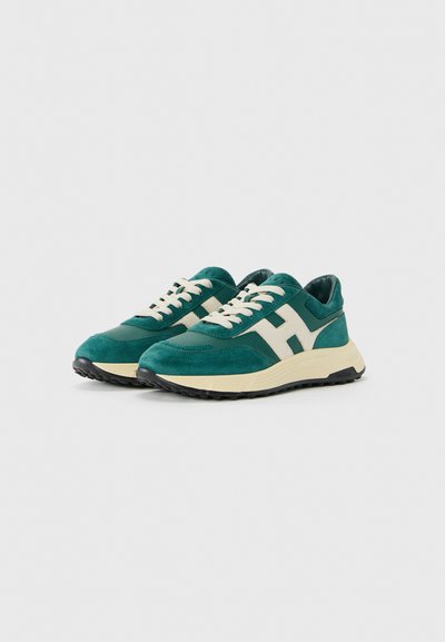 Pair of teal and cream sneakers with suede and leather details, cream laces, thick beige sole, and black treaded outsole.