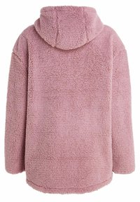 Felpa con cappuccio rosa in pile con un esterno testurizzato e morbido. Presenta un cappuccio e una vestibilità ampia, con orlo arrotondato e senza chiusure visibili.