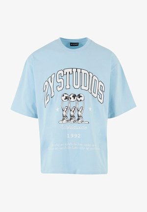 Vaaleansininen puuvillateepaita, jossa on ylisuuri malli. Paidassa on "2Y STUDIOS" -teksti, kolme hahmoa, jotka pitävät maapalloja, ja valkoinen teksti alla.