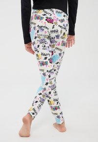 Leggings colorati con un motivo di graffiti che presenta testi e icone in rosa, blu, giallo e nero; realizzati in un tessuto elastico e liscio.