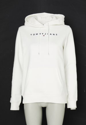 Biela mikina s kapucňou, predným vreckom a šnúrkami, logo "TOMMY JEANS" vytlačené čiernymi písmenami cez hruď s malým emblémom vlajky.