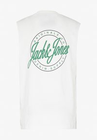 Maglietta senza maniche bianca con una grande stampa circolare verde contenente il testo "Jack & Jones" e "Denim Supply" in font corsivo e grassetto.