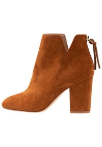 Ruskea mokkanahkasaapas nilkkoihin, jossa on blokkikorko, takakuvio, ja V-muotoinen etuleikkaus.