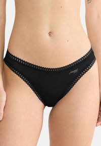 Zwart bikiniondergoed met delicate kantafwerking langs de tailleband en benen. Kenmerkt zich door een zachte stof en een logo aan de zijkant.
