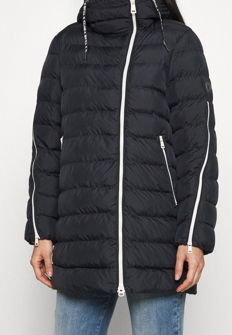 Czarna kurtka puchowa z kapturem, z poziomym pikowaniem, białymi suwakami, bocznymi kieszeniami oraz regulowanymi sznurkami w kapturze.
