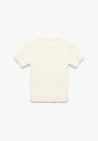 Kortærmet, hvid pullover-top lavet af blødt, tekstureret stof med en fuzzy overflade og et enkelt rundhalsdesign.