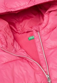 Rosa Pufferjacke mit glänzender Oberfläche, gestepptem Design und Reißverschluss. Das Innere ist mit weichem Fleece gefüttert und hat ein Markenlabel.