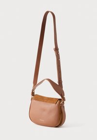 Bruine leren en suède crossbody tas met verstelbare riem en goudkleurige hardware, aan de voorkant voorzien van het merk "Coccinelle".