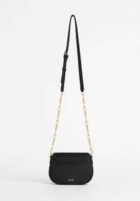 Borsa a tracolla nera in pelle con forma curva, dotata di tracolla in oro e logo impresso. Texture liscia con chiusura a patta.
