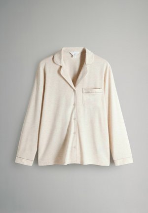 Lys beige pyjamashirt med knaplukning fortil, lange ærmer, krave og lille brystlomme. Blødt, struktureret stof.