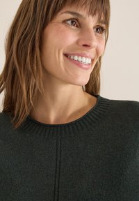 Maglione verde scuro con scollatura a girocollo a coste e design senza cuciture, caratterizzato da una texture liscia e da un leggero lucido nel tessuto.
