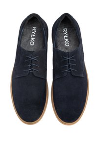 Zapatos de ante navy con una textura suave, que presentan un diseño de cordones, punta redondeada y una suela de color marrón claro en contraste. Logo de la marca en el interior.