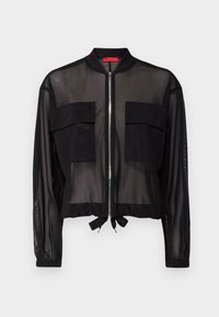 Chaqueta bomber negra con tejido transparente, dos bolsillos frontales, puños elásticos y un lazo en la cintura en el dobladillo. Cierre frontal con cremallera.