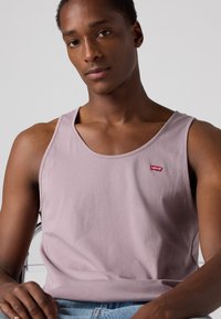 Top de alças lavanda em algodão, com decote redondo e um pequeno logótipo vermelho da Levi's no peito; textura suave e corte casual.