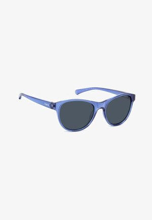 Lunettes de soleil en plastique violet avec des verres foncés et une forme œil de chat. Présentent des branches fines avec un logo blanc sur les tempes.