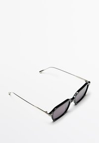 Zwarte zonnebril met een vierkant montuur, donkere lenzen en zilveren metalen accenten op de armen. Glad oppervlak met een minimalistisch ontwerp.