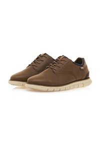 Zapatos de cuero marrón con un acabado suave, diseño de cordones y suela acolchada beige. Presentan costuras sutiles y un detalle de marca.