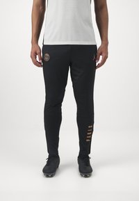 Svarta träningsbyxor med slim fit, med orange Paris-logotyp och text, tillverkade av ett slätt, stretchigt material.
