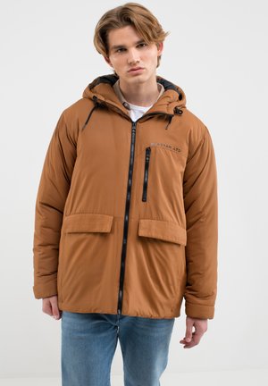 Hnědá péřová bunda s předním zipem, dvěma velkými předními kapsami a kapucí. Obsahuje černý zip a logo značky na hrudi.