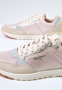 Låga sneakers med ovandel i nät och mocka i beige och ljusblått. Har metalliska detaljer, rund tå och gummisula.