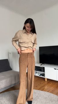 Chemise beige à boutons avec deux poches, associée à un pantalon large en daim marron avec poches avant et texture lisse.