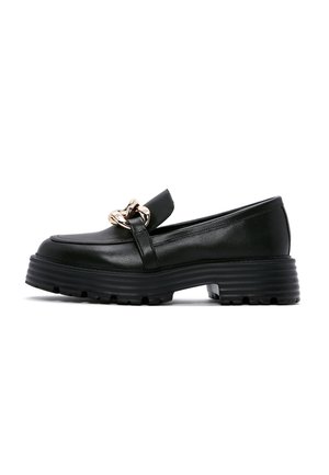 Sort læderloafer med chunky ribbede såler og guldkædedetalje foran, fotograferet mod en hvid baggrund.