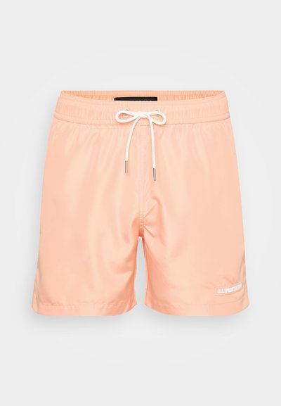 Shorts de bain en pêche clair fabriqués en tissu lisse et léger. Présentent une taille élastique avec cordon de serrage et un logo blanc sur la jambe inférieure gauche.