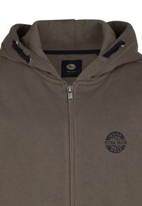 Sudadera con cremallera de color marrón, con capucha y cordones, que presenta un pequeño logo circular oscuro de "Petrol Driven Work Wear" en el pecho.