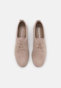 Scarpe beige in suede con design a lacci, punta tondeggiante e superficie liscia. Caratterizzate da cuciture sottili e una soletta con marchio.