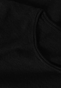 Tessuto di cotone nero con una texture liscia, caratterizzato da un collo arrotondato e dettagli delle cuciture. Il materiale è morbido e leggermente peloso.