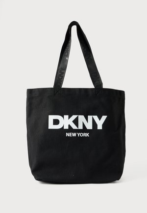 Fekete vászon bevásárlótáska két felső fogóval, amelyen nagy fehér betűkkel olvasható a "DKNY" és a "NEW YORK" felirat.
