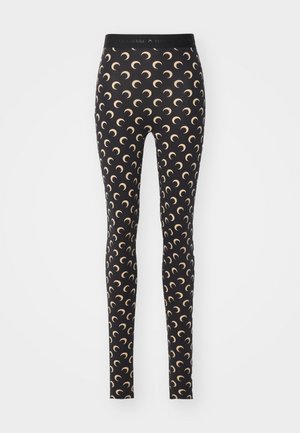 Leggings noirs avec un motif de croissant de lune en beige clair. Fabriqués en tissu extensible avec une taille élastique.