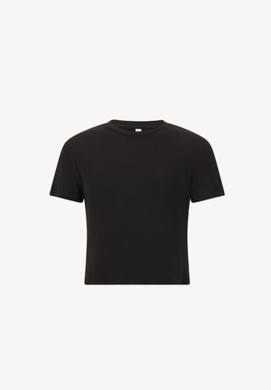 Sort, riflet kortærmet top parret med sorte leggings. Leggingsene har en glat tekstur og en subtil logo-detalje. Hvide sneakers fuldender outfittet.