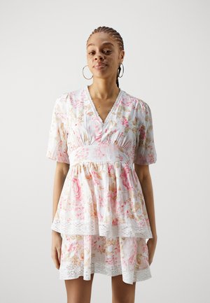 Floral print dress with short puff sleeves, V-neck, and tiered ruffle hem. Features a smocked waist and lace trim at the hem. Colorful pastel tones.