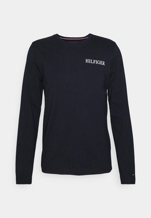 Chemise bleu marine à manches longues avec logo "HILFIGER" sur la poitrine et petit détail logo sur le poignet gauche.